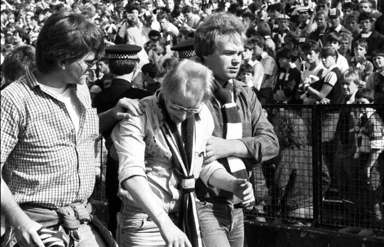 Friends help an injured fan after crowd trouble during the Hibs v Hearts Edinburgh derby football match at Easter Road in August 1984. Final score 1-2 to Hearts